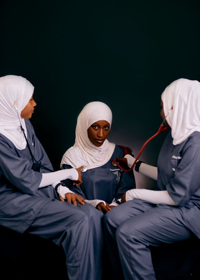 Three female healthcare professionals in uniforms with stethoscope. Medical setting.